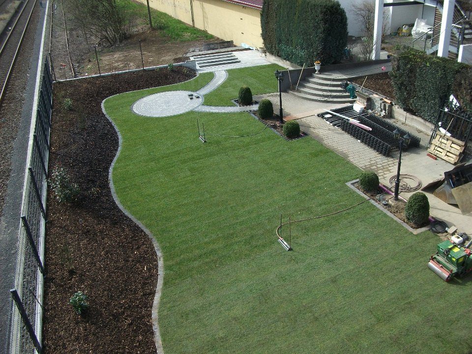 Gartenanlage mit geschwungenen Wegen, Rasen und Beeten
